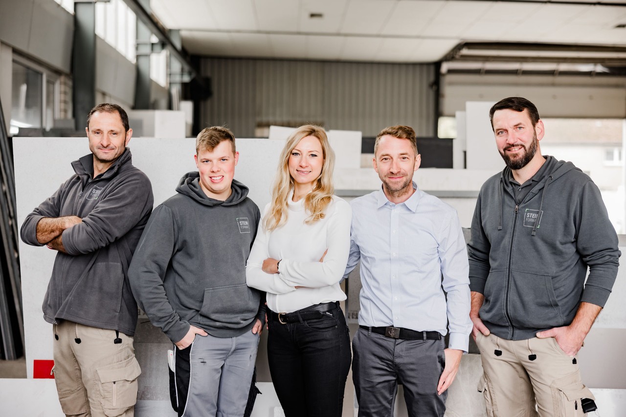 Teamfoto von Steinformat 2023 mit fünf Mitarbeitenden in der Werkstatt