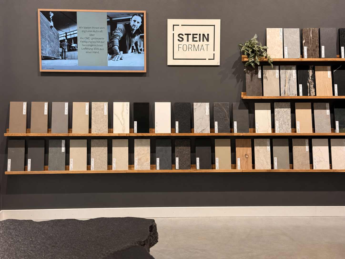 Ausstellungsbereich eines Küchenstudio-Partners mit Steinformat-Logo und übersichtlich angeordneten Materialmustern
